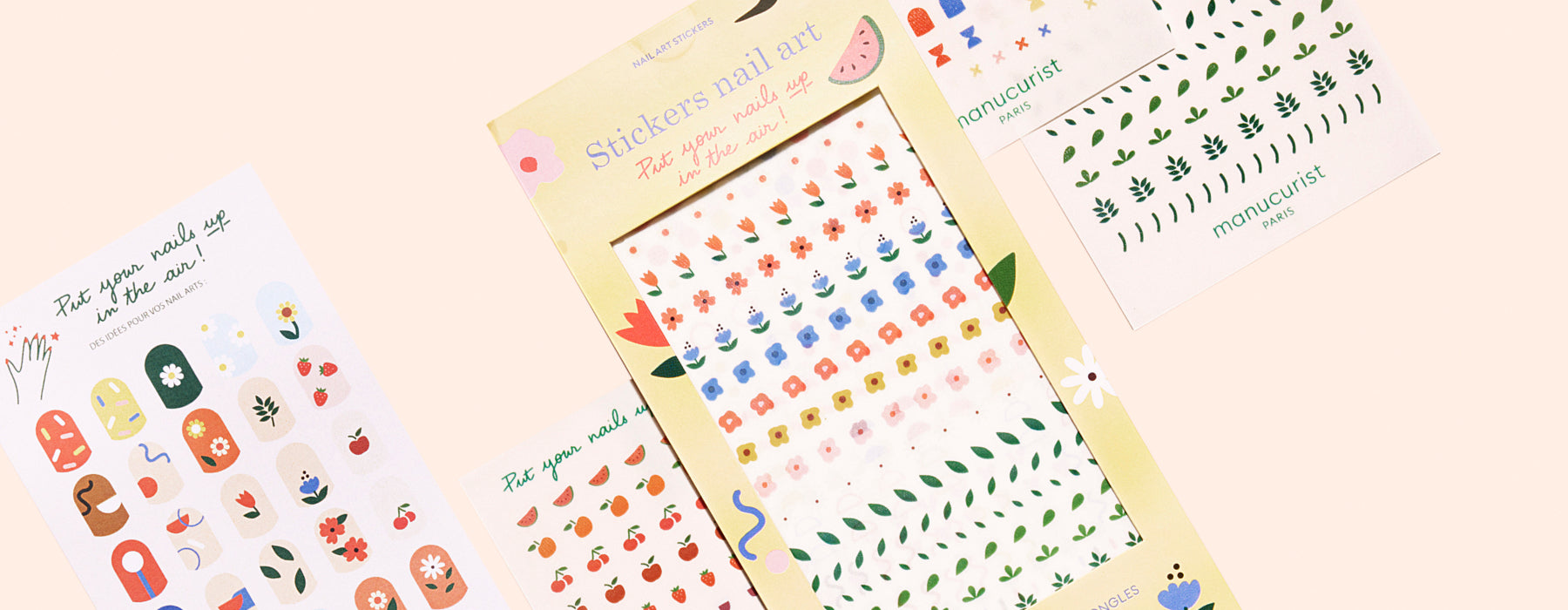 A set of colorful nail art stickers featuring flowers, leaves, and abstract designs, displayed in packaging and on sheets against a light peach background.