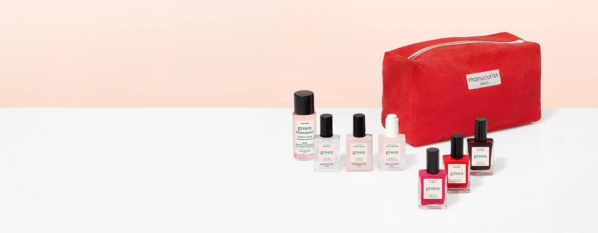 A red Maniocurist Paris pouch sits beside seven bottles of nail polish and nail care products in various colors, arranged in a row on a white surface with a pale peach background.