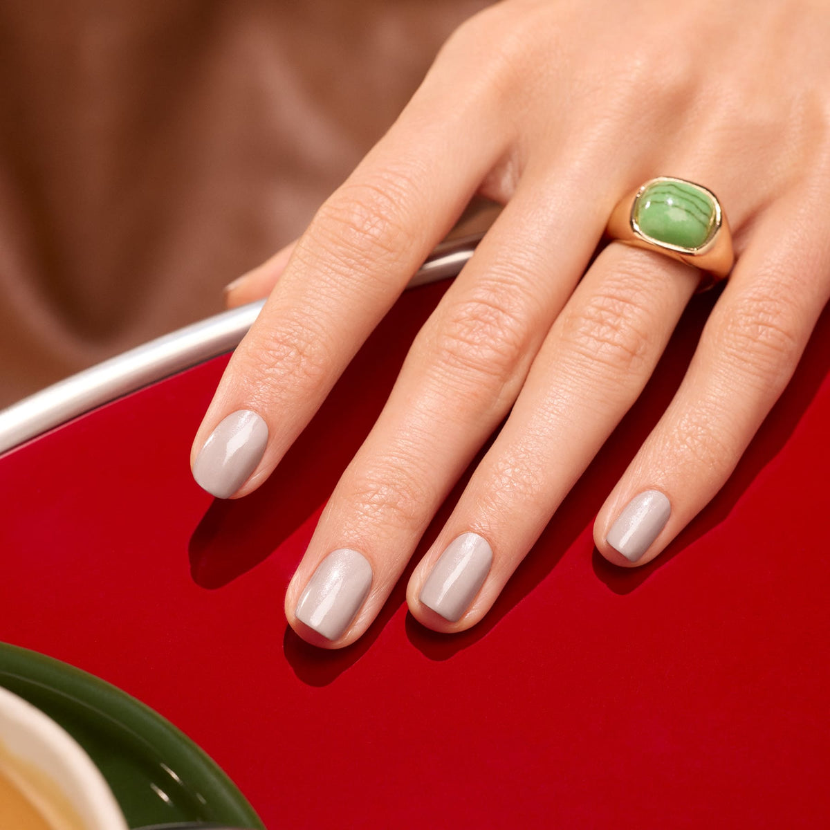 A hand with neatly manicured nails painted in Manucurist&