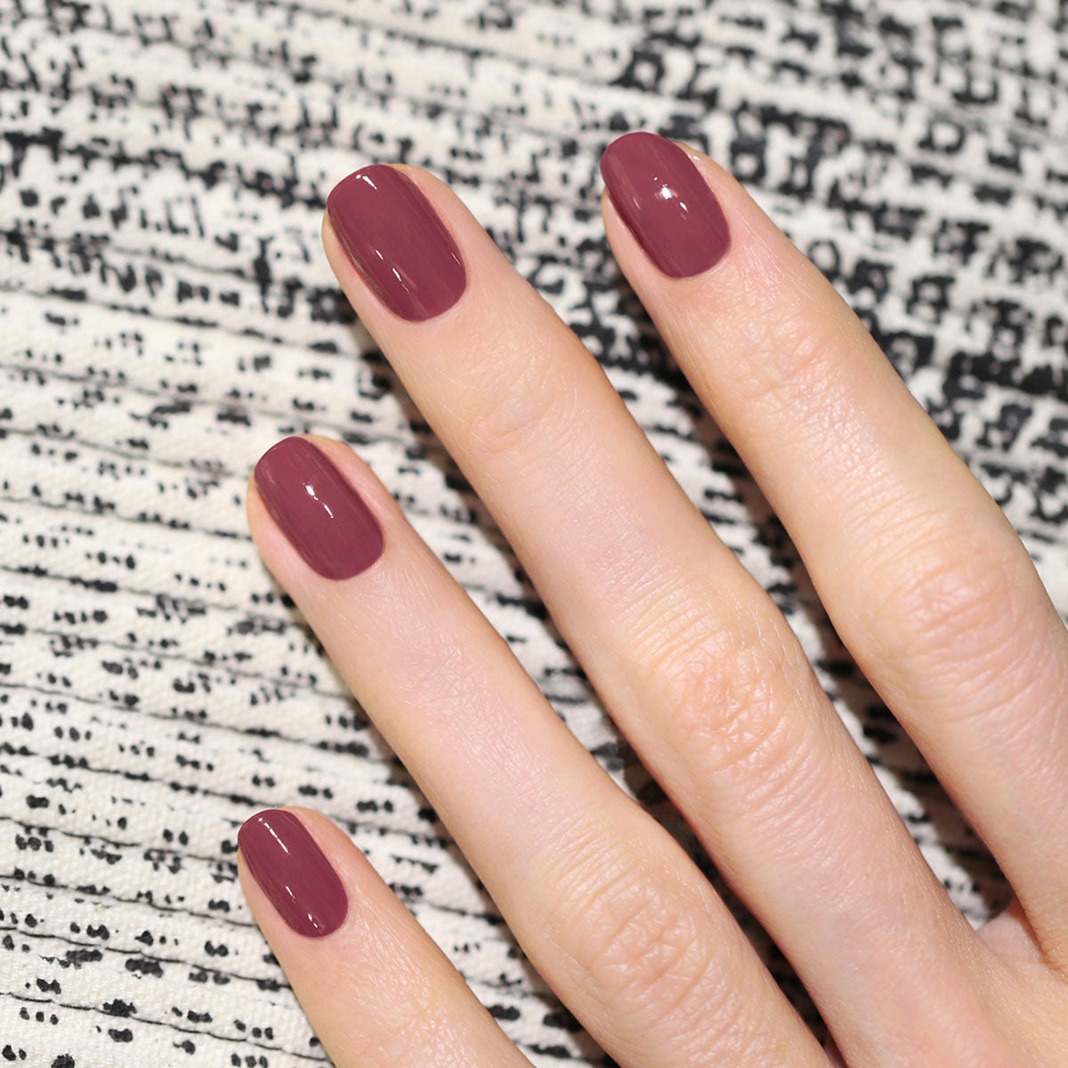 A hand with neatly manicured nails painted in Manucurist&