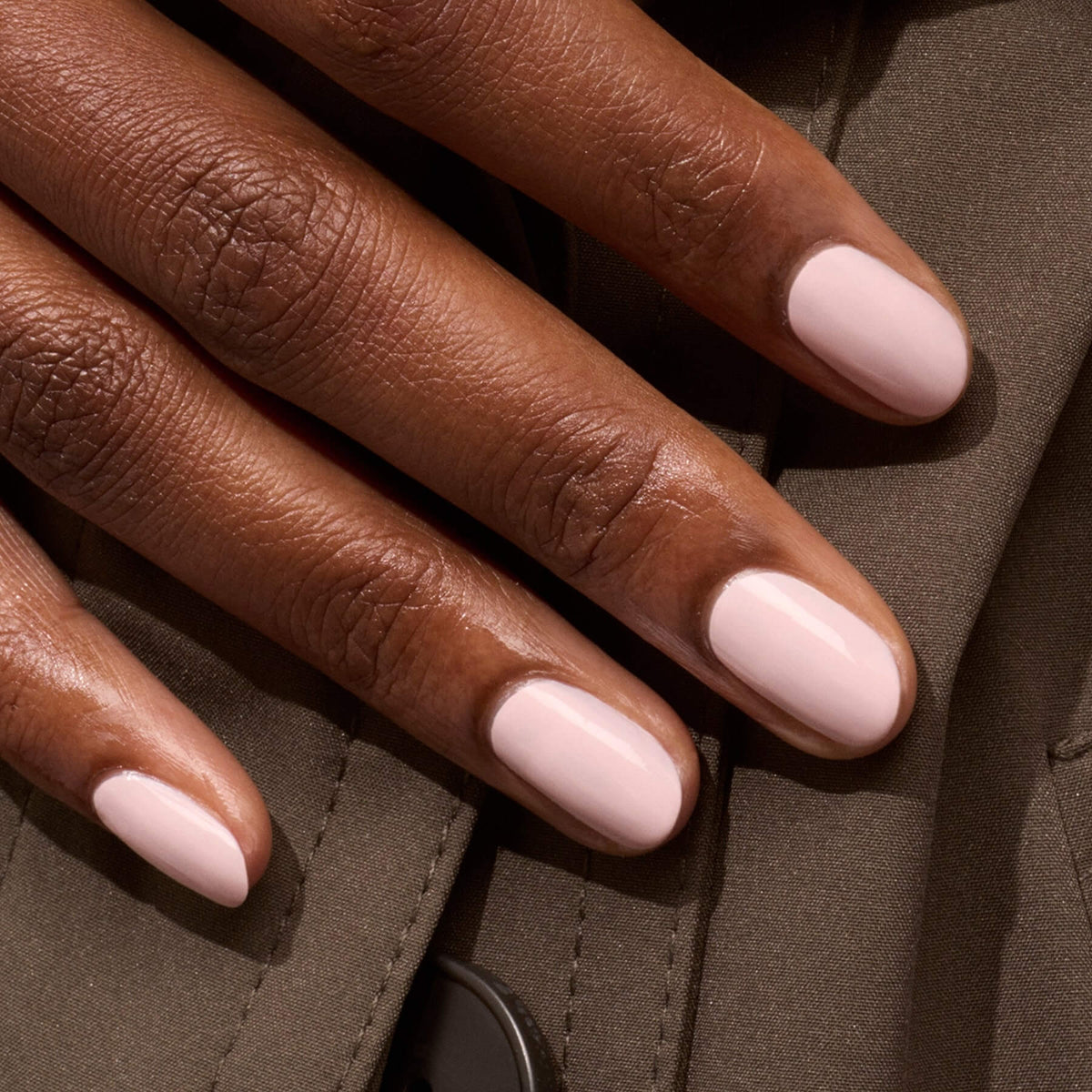 A close-up of a hand with short, manicured nails painted in Manucurist&