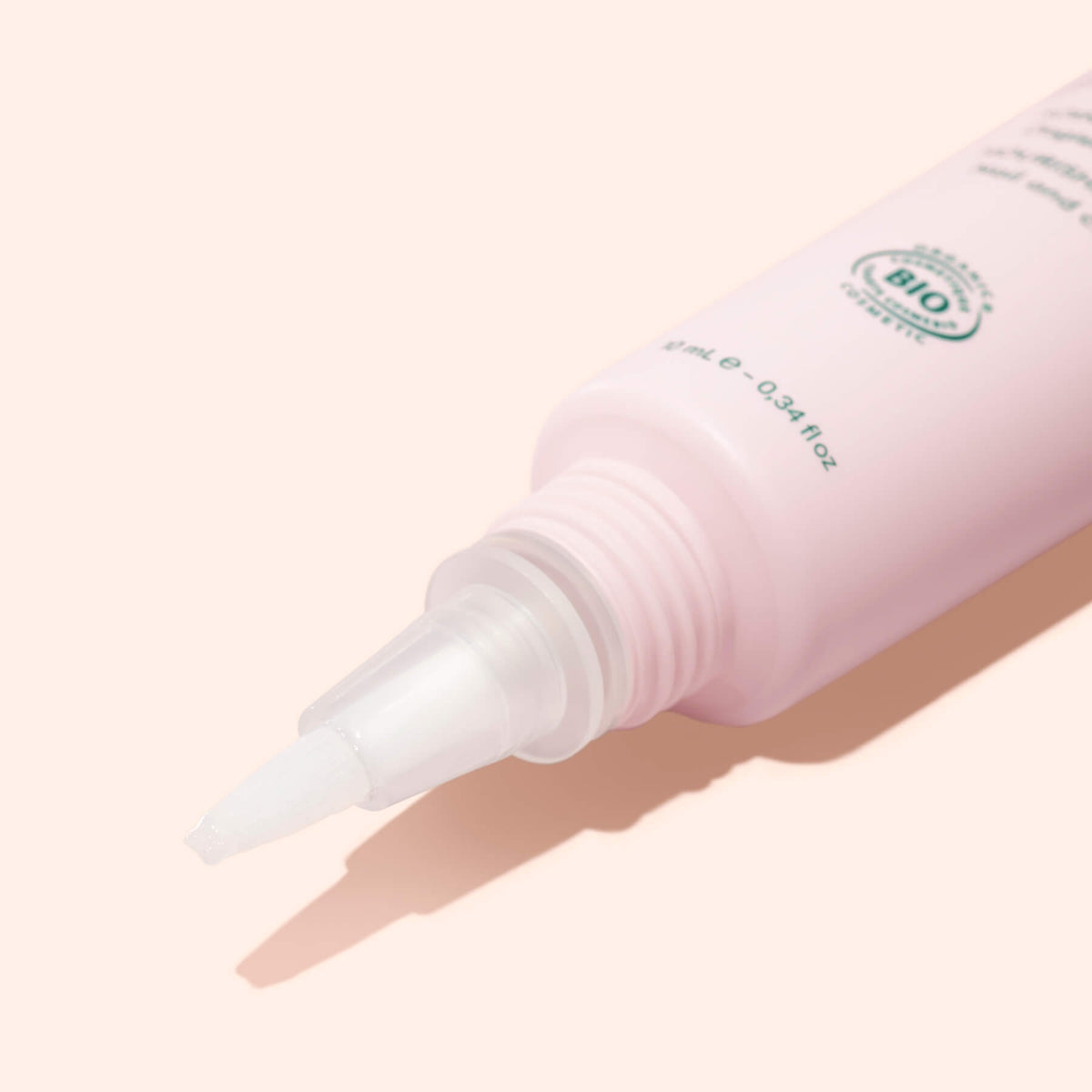 Close-up of a pale pink Manucurist Nourishing Nail Pen - Cosmos Organic with a pointed applicator tip and an organic certification label.