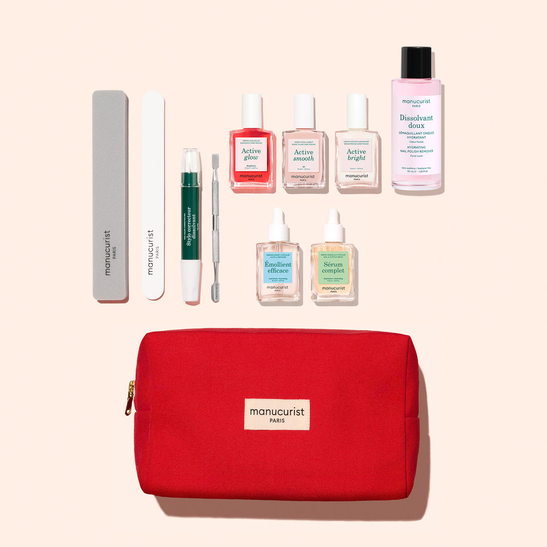 The Manucurist Ultimate Active Manicure Kit features a vibrant red pouch containing a comprehensive nail care set—including a buffer, file, cuticle remover pen, metal tool, three polish bottles, base coat and top coat bottles, and nail polish remover—all beautifully arranged on a light background for healthy nails.