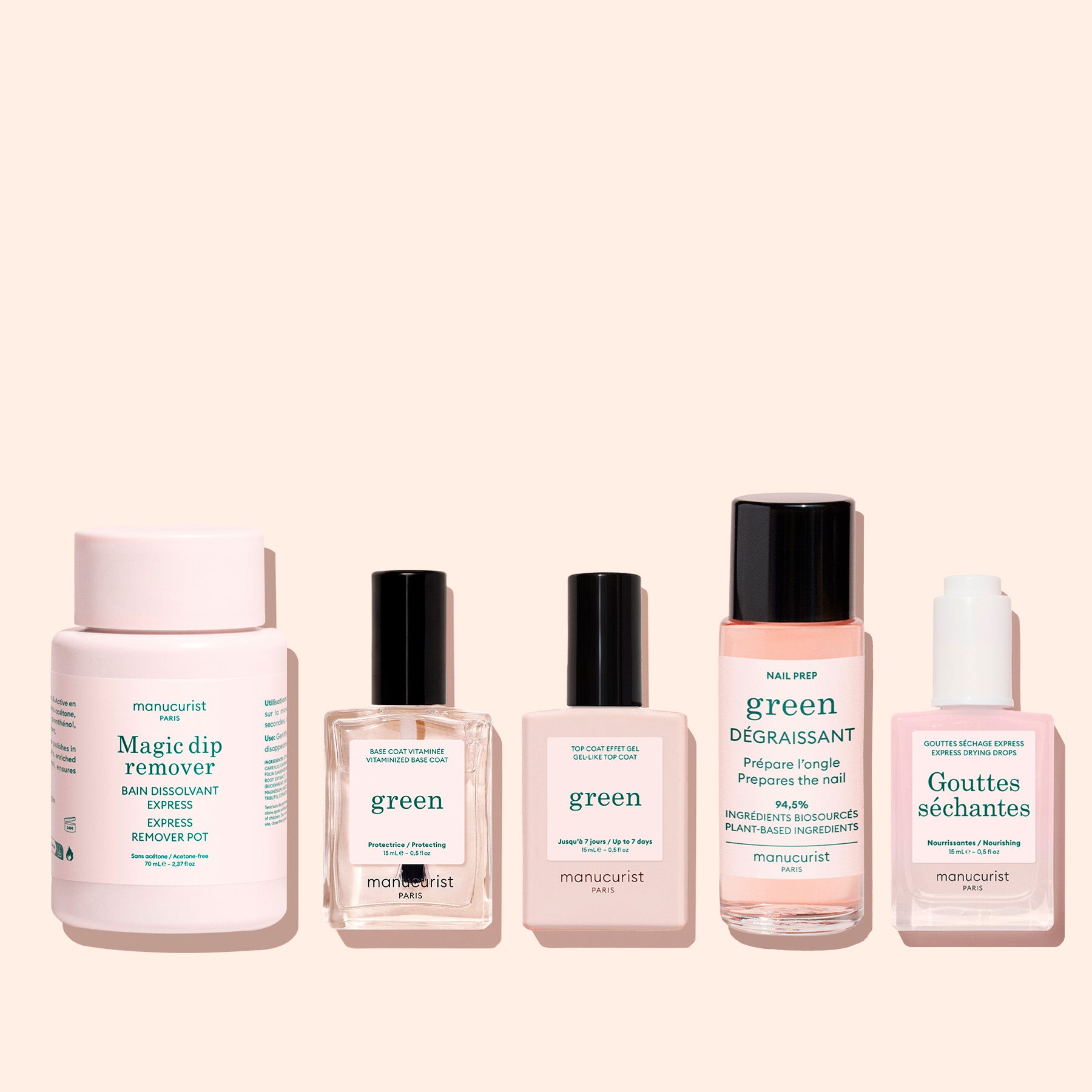 Five travel-friendly manicure products in clear and pink bottles with black lids, labeled Manucurist, are displayed in a row on a light peach background—including the acetone-free Magic Dip Remover.