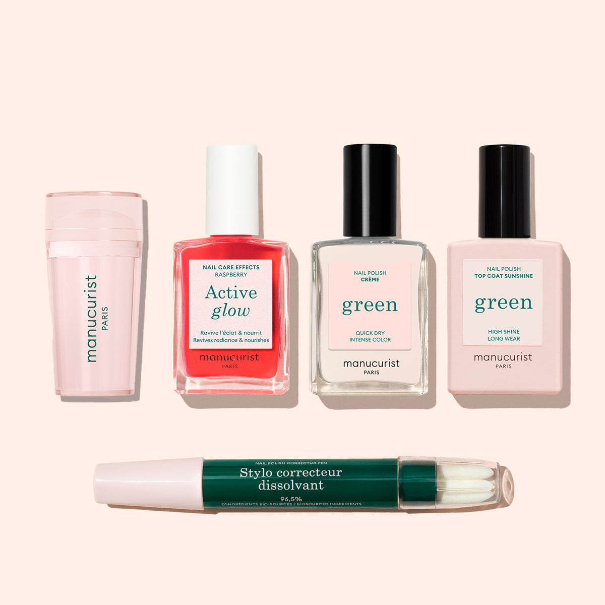 Cinq produits de manucure sur fond clair : le tampon nail art Manucurist US, un étui cylindrique rose, des flacons de vernis rouge et transparent, un flacon de Top Coat et un stylo dissolvant vert — idéal pour une French manucure impeccable ou sublimée.