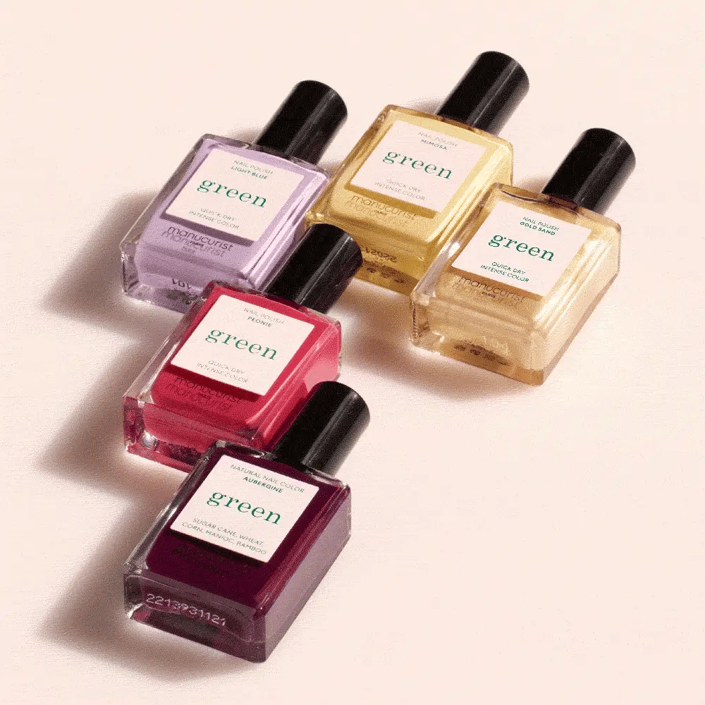 Five bottles of green nail polish in assorted pastel shades, including light yellow, lavender, pink, and deep purple, arranged in a staggered pattern on a light background.