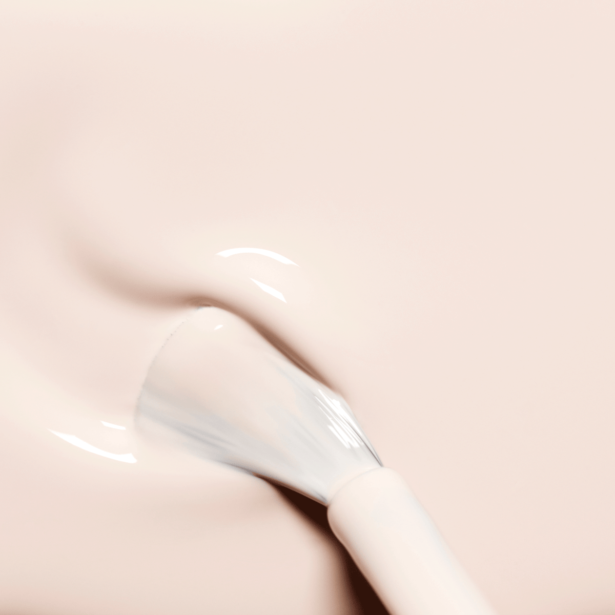 Un pinceau applique Manucurist Crème, un vernis gel rose pâle laiteux, sur les ongles pour un fini lisse et brillant avec de subtils reflets.