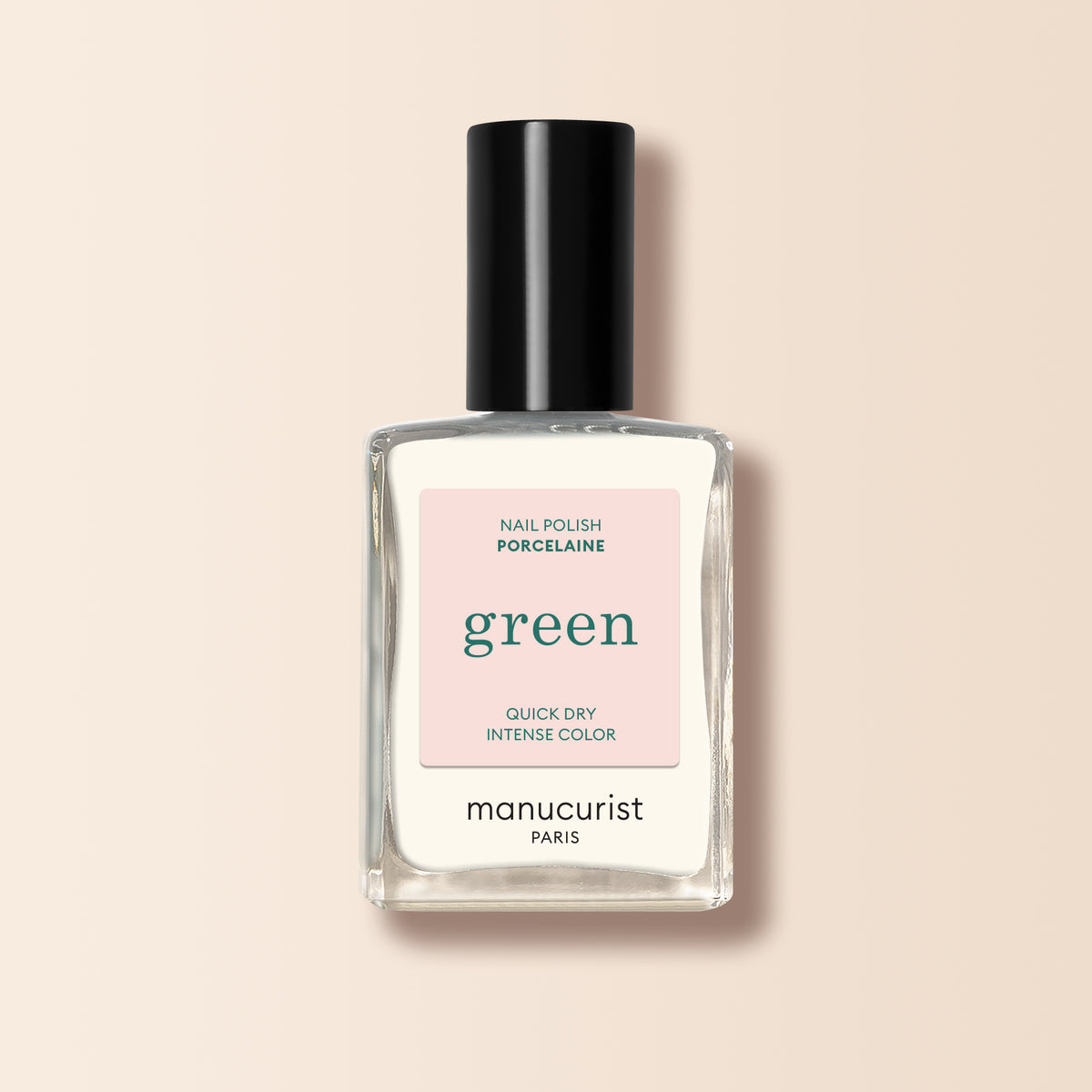A clear glass bottle of Manucurist Porcelaine nail polish with a black cap, labeled "Quick Dry Intense Color," is displayed against a light beige background.