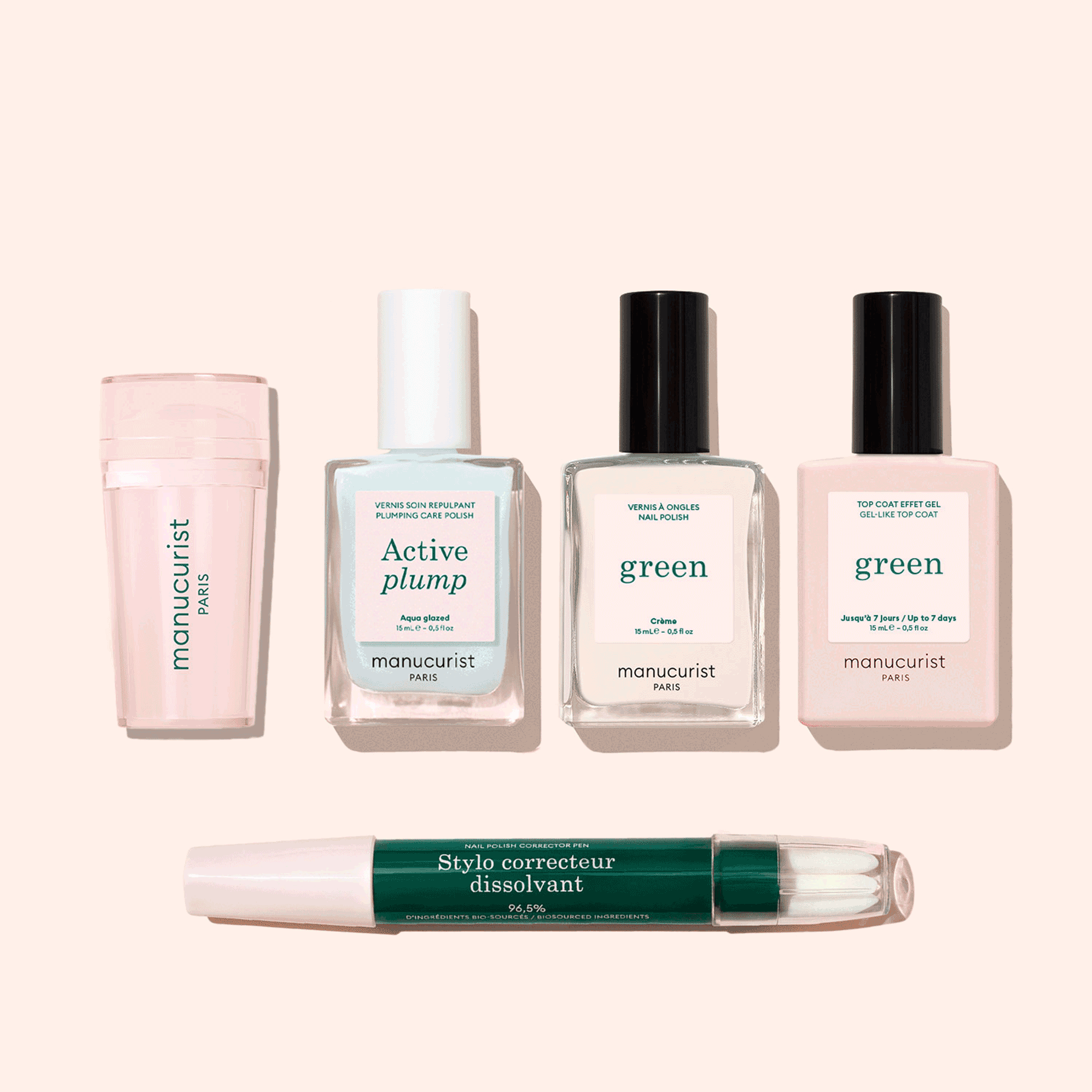 Five manicure products from Manucurist’s French Active™ Kit are shown on a beige background: a pink cylindrical container, a square bottle labeled Active blur, two green-labeled nail polish bottles, and a dual-ended Stylo correcteur pen.