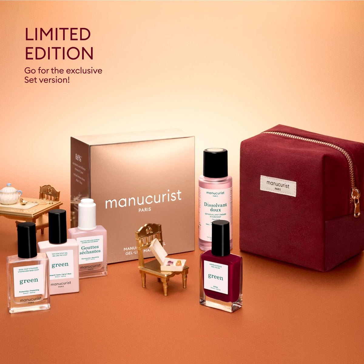 The Manucurist Green™ Discovery Kit Gift Set includes naturally derived nail polishes, remover, base coat, oil drops, a burgundy cosmetic bag, and miniature furniture—all beautifully presented on a peach background—making it the perfect limited edition holiday gift for achieving a gel effect manicure at home.