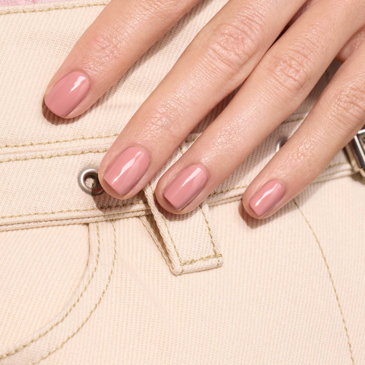 A hand with neatly manicured nails painted in Old Rose, a glossy antique powder pink shade from Manucurist&