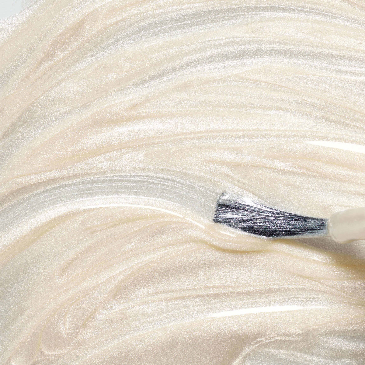 A close-up of a brush spreading Manucurist&