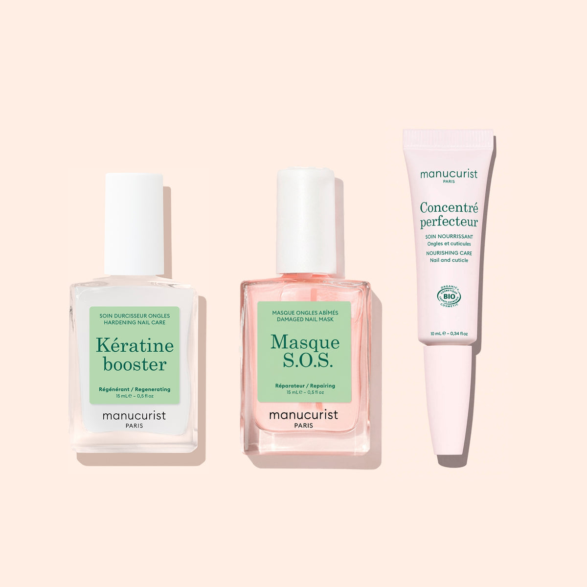 Three manicure products for nail care on a light pink background: a square bottle of Manucurist Nail Strengthening Serum, a square bottle of Masque S.O.S. overnight nail mask, and a tube of Concentré perfecteur.