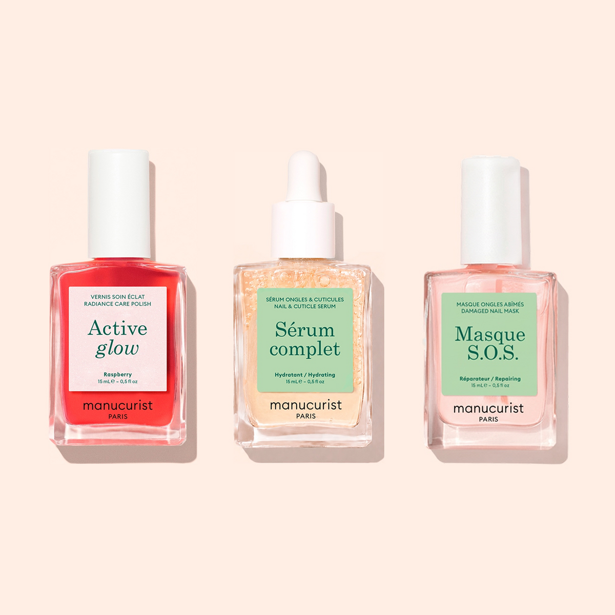 Trois soins pour les ongles dans des flacons compte-gouttes en verre présentés côte à côte sur fond beige : Routine Essentielle - Ongles Sensibles par Manucurist, offrant des solutions de soin indispensables spécialement conçues pour les ongles sensibles.