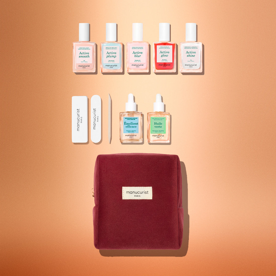 The Manucurist Active™ Super Starter Gift Set makes a perfect holiday gift, featuring six nail polish bottles, two cuticle treatments, two nail files, a cuticle pusher, and a burgundy velvet pouch—all beautifully arranged on a peach-colored background to help you achieve beautiful nails as part of your manicure routine.