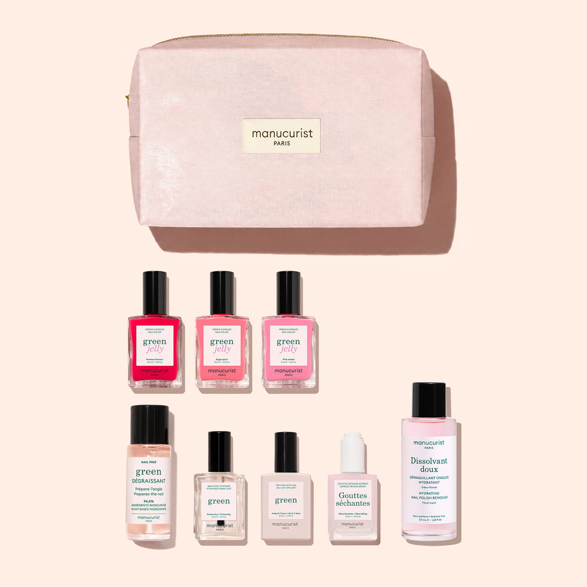 A pink Manucurist pouch containing the Starter Kit - Jelly Nail Polish, which includes eight essentials for a Green manicure—plant-based jelly nail polishes in pink and red shades, remover, base coat, top coat, nail oil, and softening drops—all beautifully arranged on a light background.