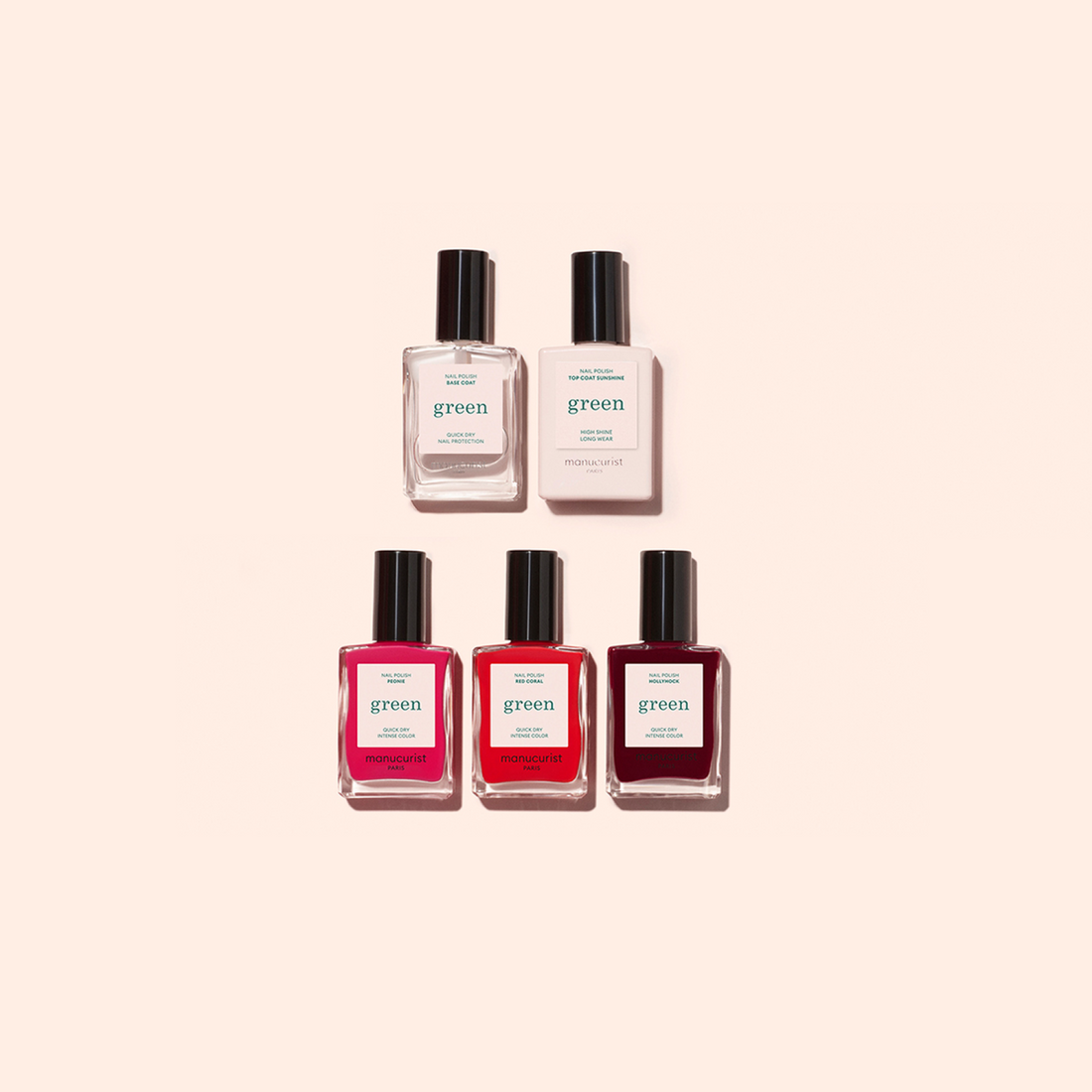 Five nail polish bottles from the Welcome kit Green by Manucurist-test are arranged in two rows on a beige background: two clear bottles above three in pink and red shades.