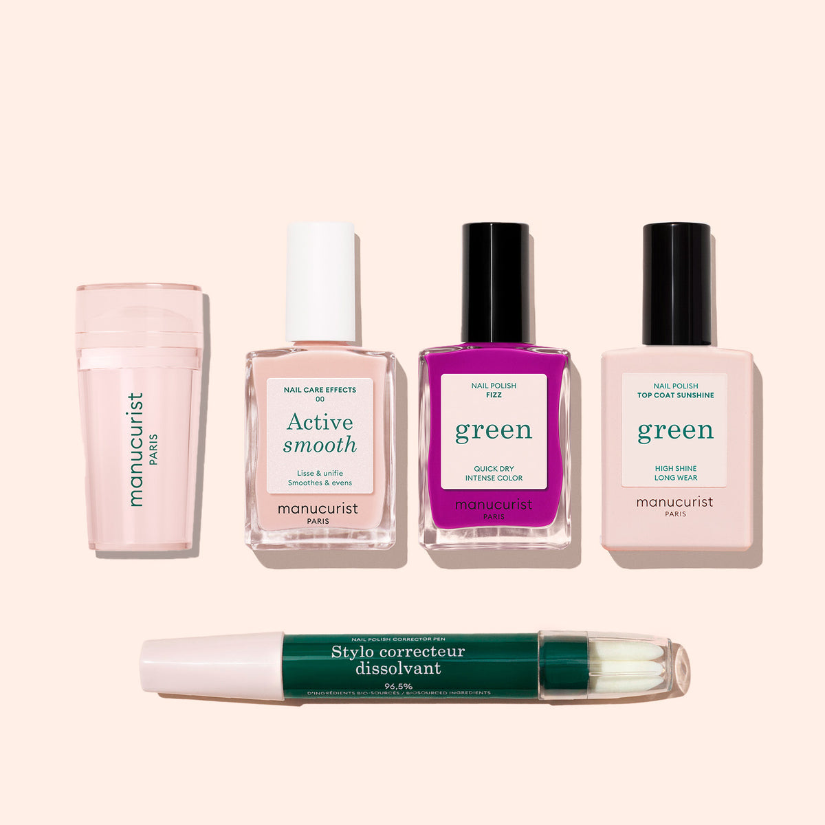Cinq produits de manucure du French Color Kit de Manucurist sont présentés sur un fond beige clair : un polissoir à ongles, deux vernis nude, un vernis rose vif, un top coat et un stylo correcteur vert.