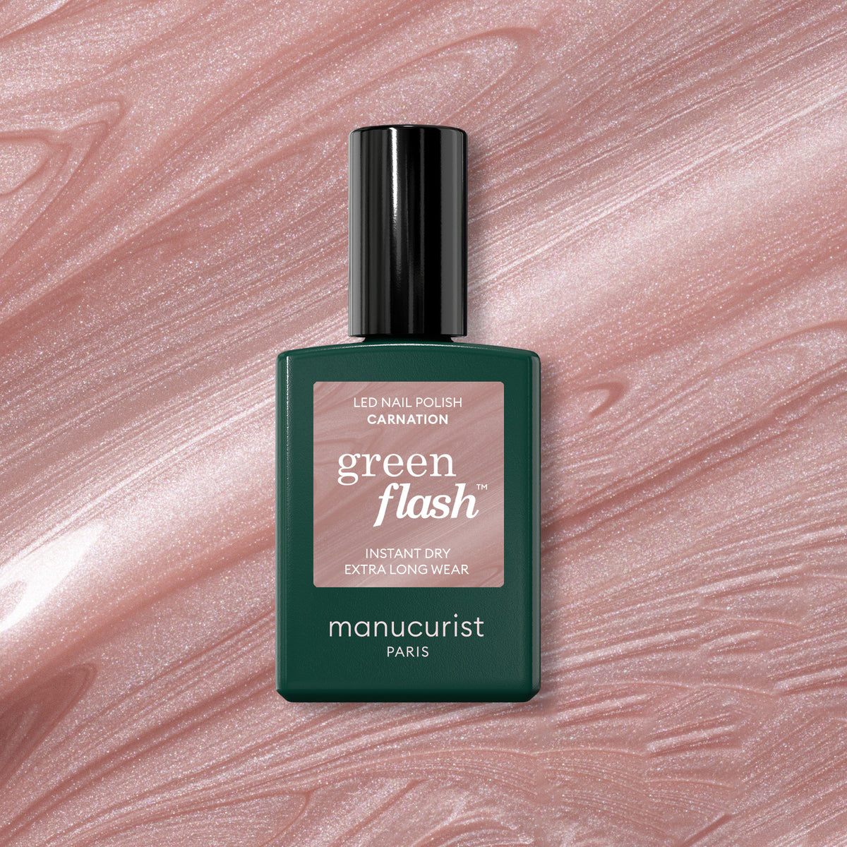 Un flacon de vernis gel Green Flash Carnation de Manucurist est présenté sur une surface marbrée scintillante rose nacré, rappelant du vernis à ongles.