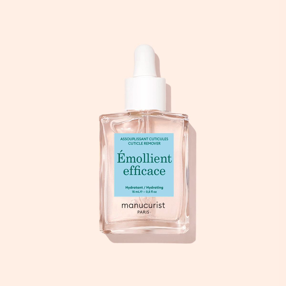 Un flacon de Soin Hydratant Cuticules Manucurist, avec son pratique compte-gouttes, est posé à côté d&