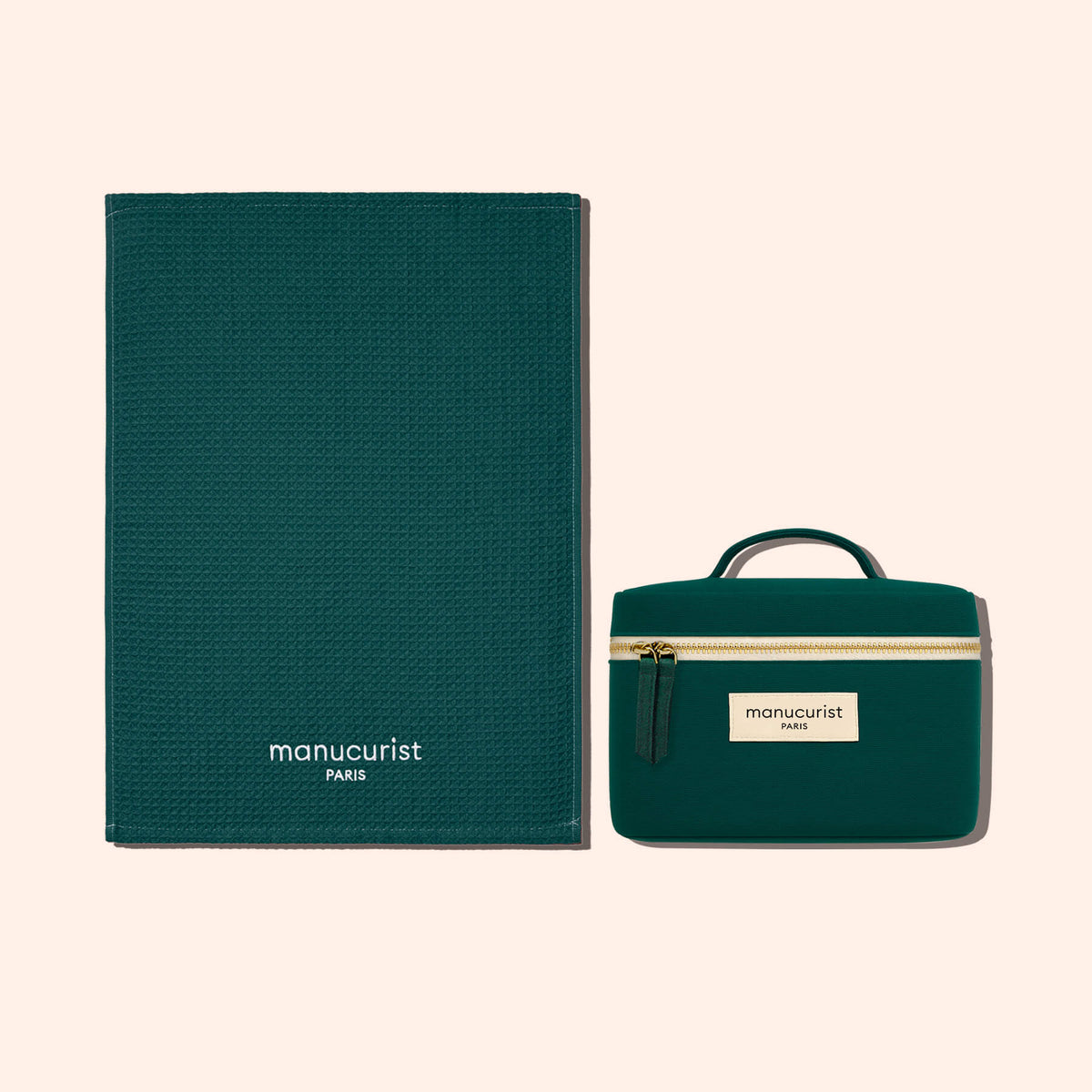 Une serviette en coton biologique texturé vert foncé de Manucurist-us et une pochette zippée assortie offrent une protection élégante pour les surfaces, toutes deux marquées de la marque et présentées sur un fond beige clair.