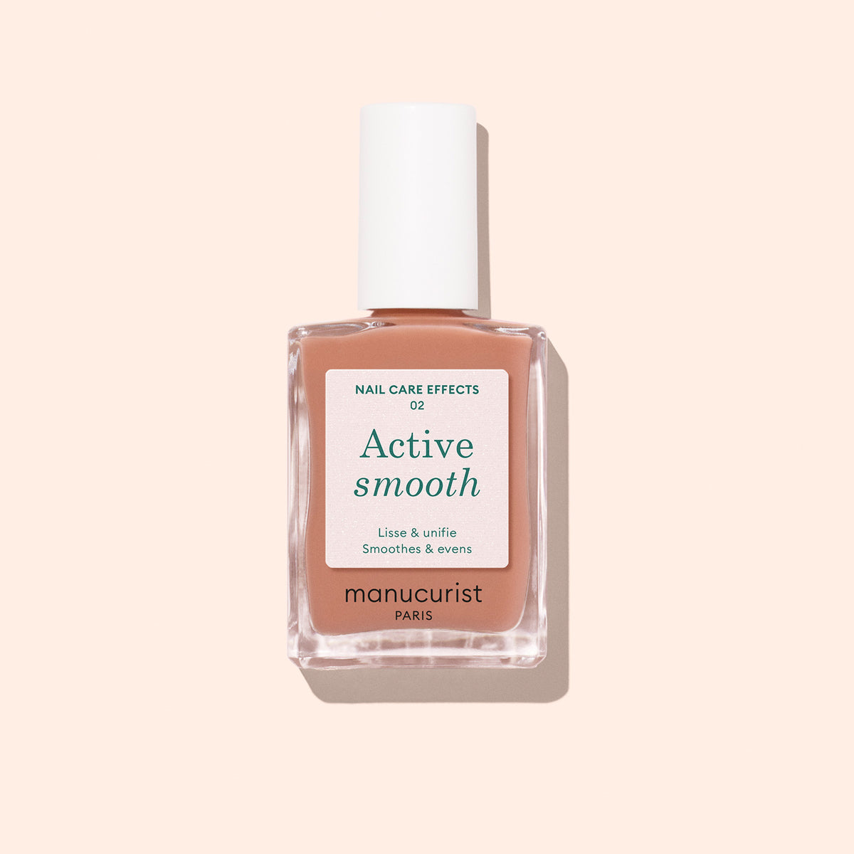 Un flacon de vernis soin Manucurist Active™ Smooth 02 au bouchon blanc, sur un fond pêche pâle. L&