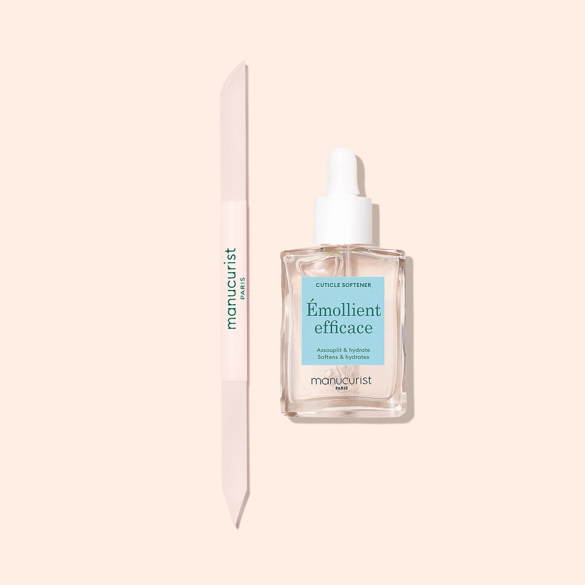 Le repousse-cuticules en verre Manucurist et un flacon d’adoucissant pour cuticules Émollient Efficace avec compte-gouttes sont présentés sur un fond beige clair, idéal pour un soin précis du contour de l’ongle.