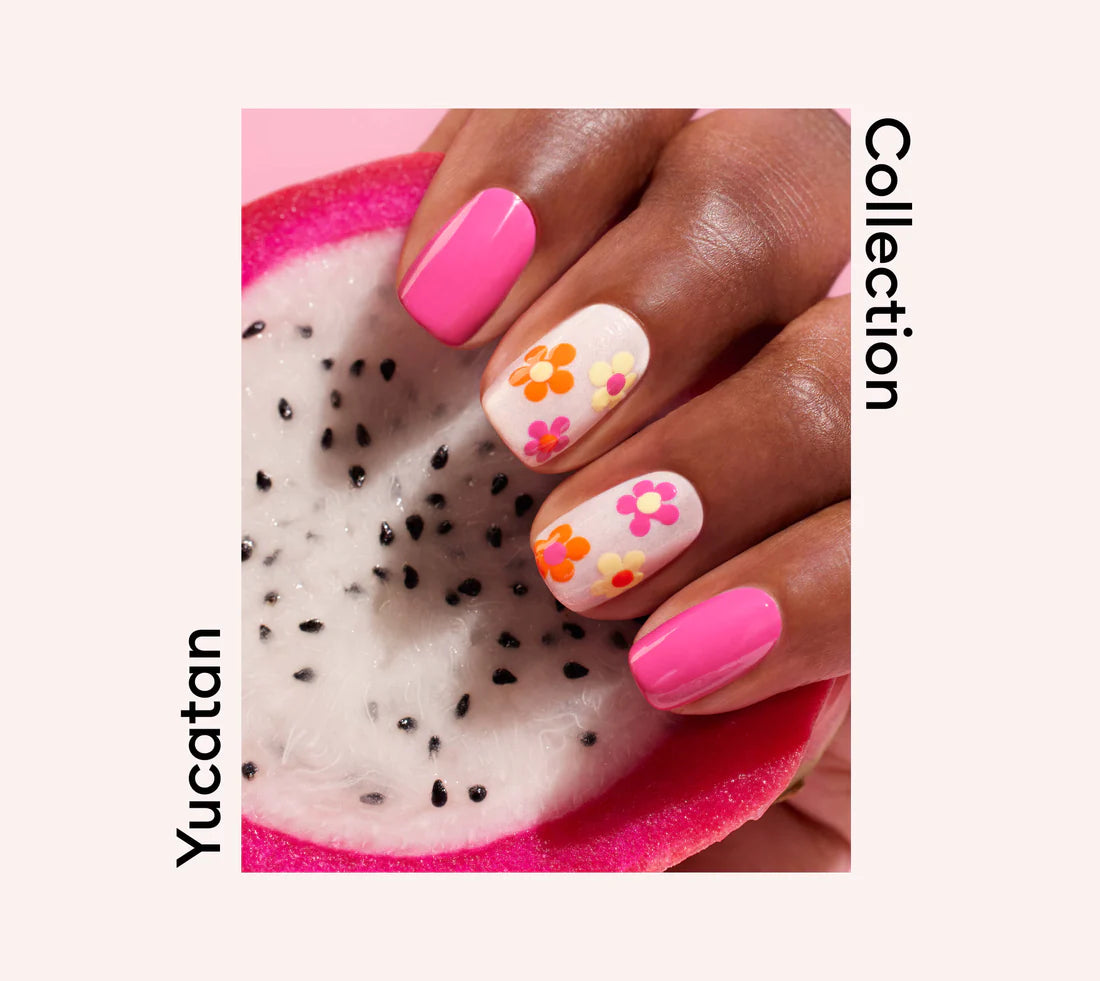 A hand with pink and white nails featuring colorful flower designs holds half a dragon fruit. The words Yucatan Collection appear around the image on a light background.