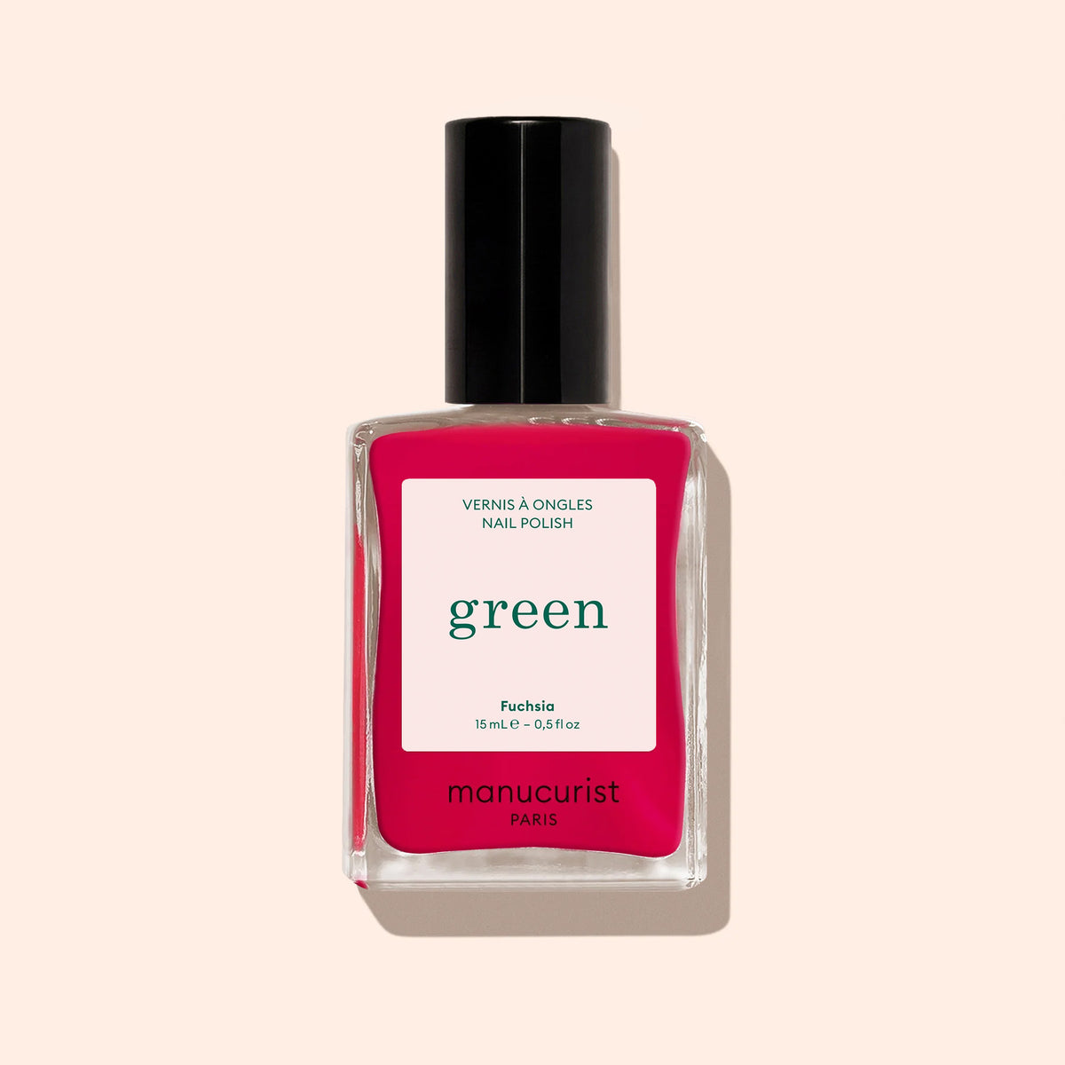 Un flacon de vernis à ongles Manucurist Fuchsia avec bouchon noir et une teinte rose violacé vibrante, issu de la gamme Green™, présenté sur fond beige clair.