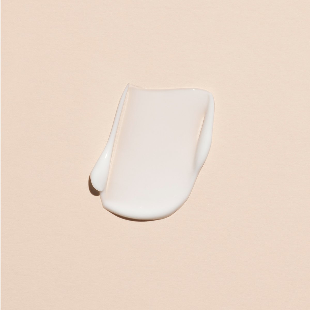 Une noisette de crème pour les mains Manucurist Everyday Lavender – Cosmos Organic est étalée sur une surface lisse beige clair.