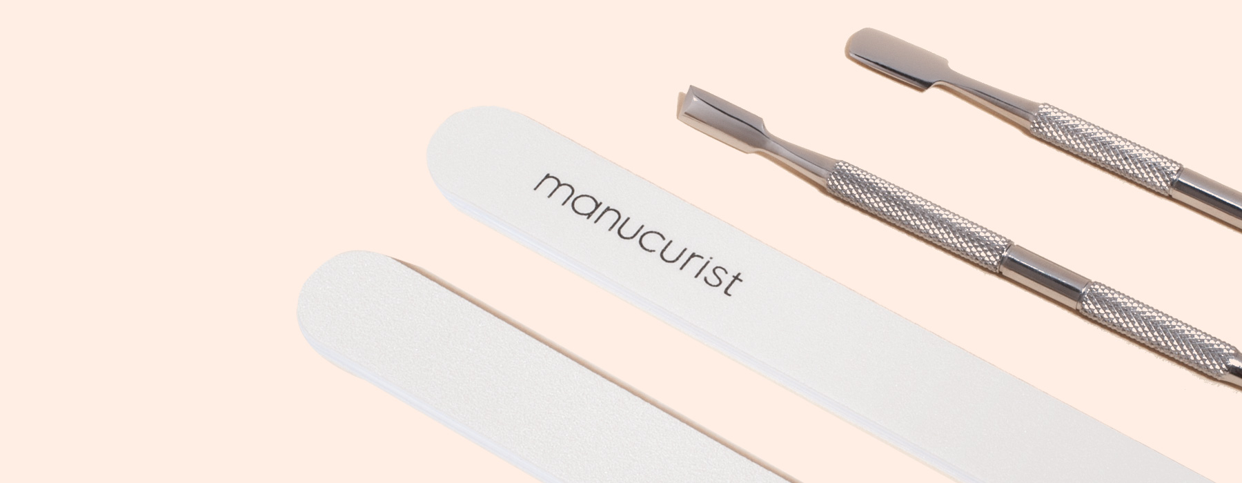 A nail file labeled manucurist, a blue egg-shaped object with M7XQ, and two metal cuticle pushers on a light beige background.