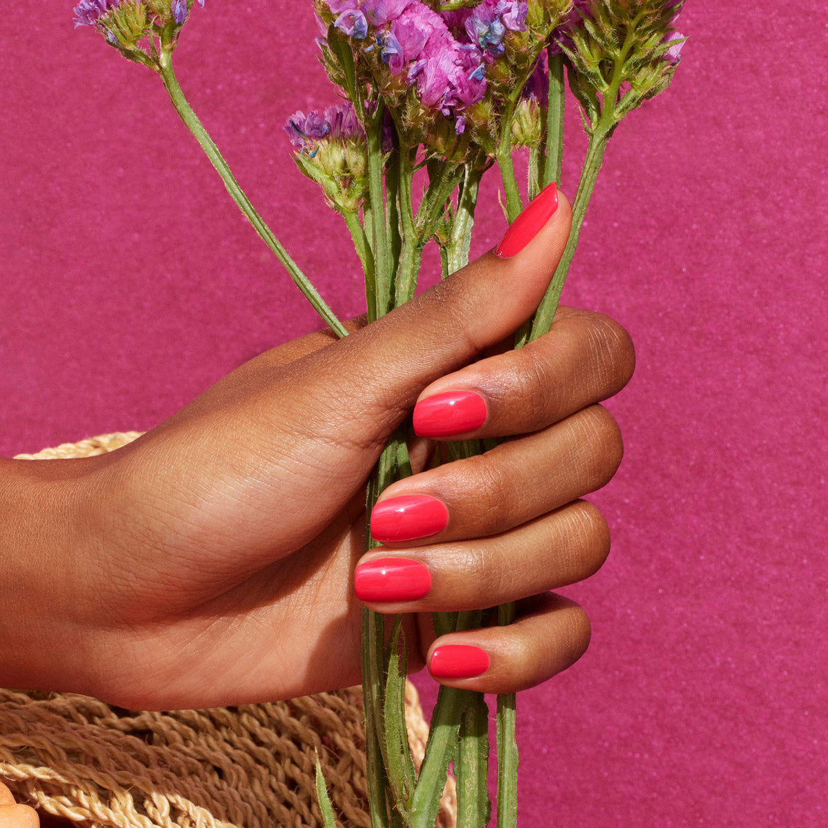 A hand with neatly manicured, glossy pink nails polished in Manucurist&