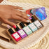 Une main aux ongles multicolores repose sur un tapis tressé à côté d&