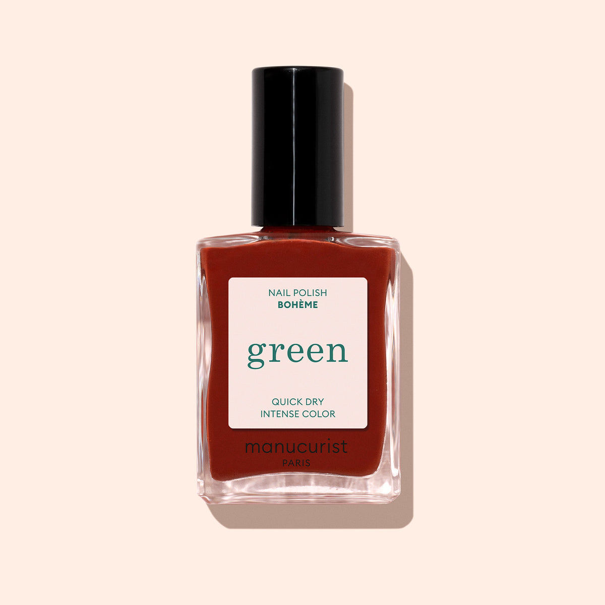 A bottle of Manucurist Bohème nail polish, labeled "green" and "QUICK DRY INTENSE COLOR," features deep red with brown undertones and a black cap, set against a light beige background.