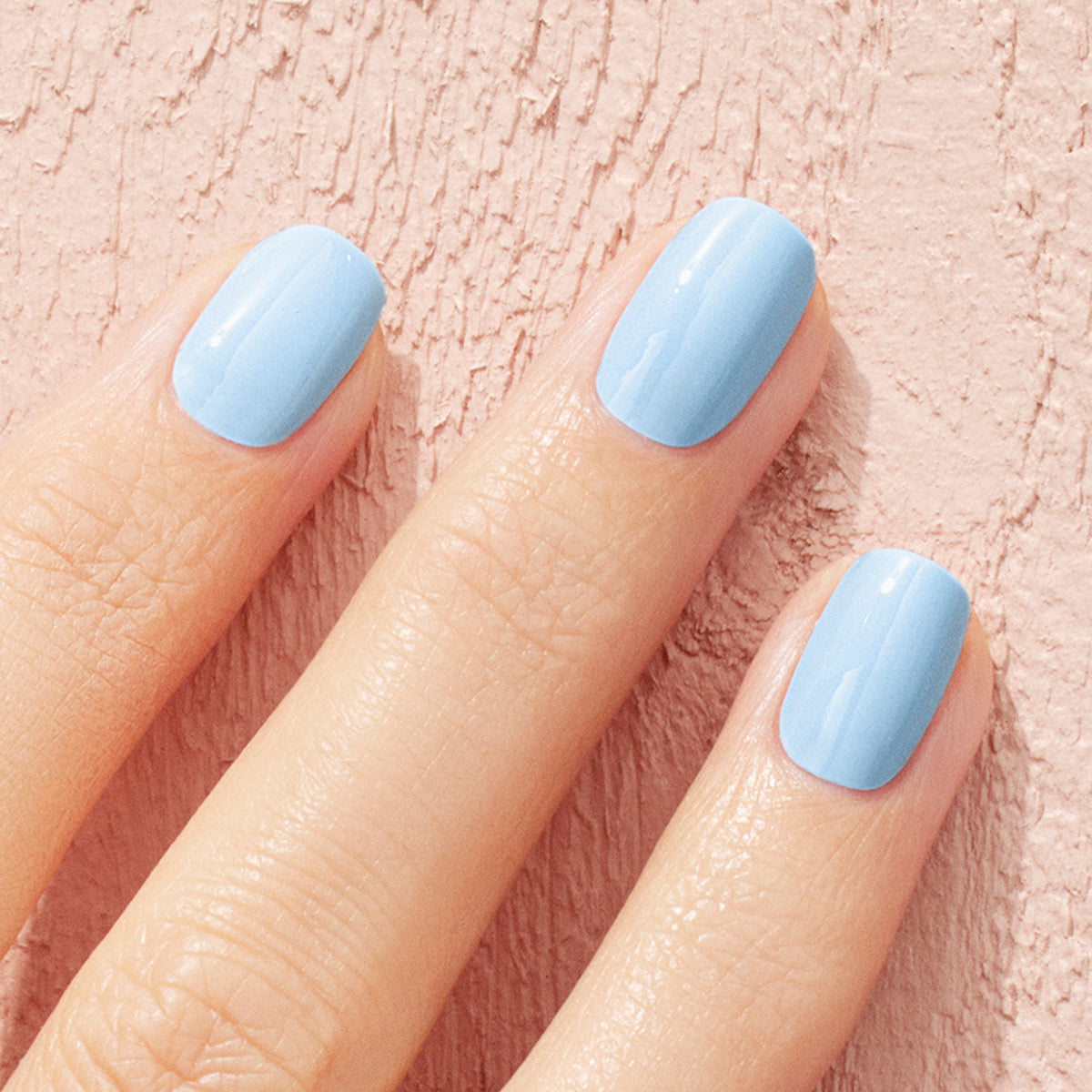 A close-up of three fingers with neatly manicured nails painted in Manucurist&