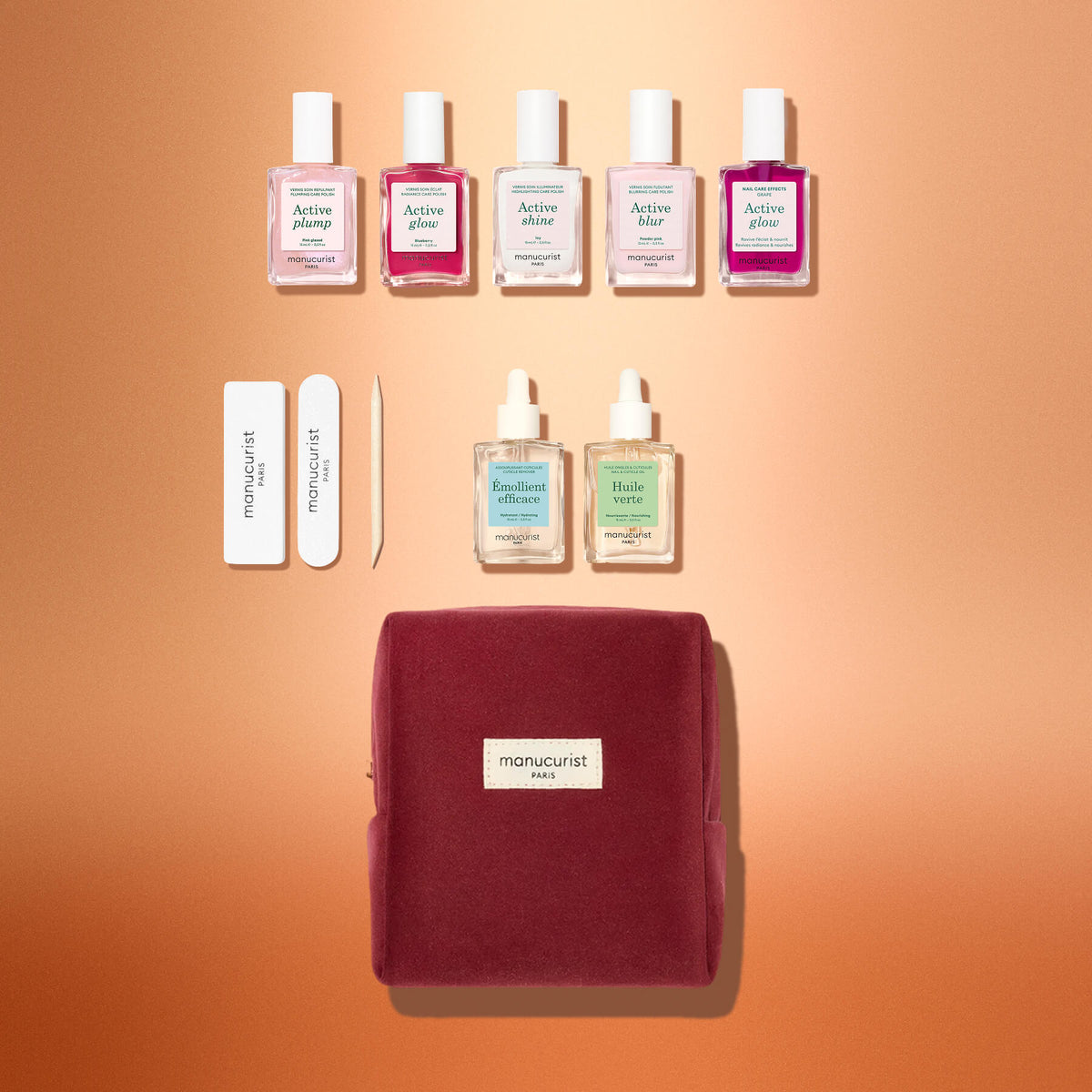 Le coffret cadeau Manucurist Active™ Starter Kit, avec cinq flacons de vernis à ongles, deux flacons en verre avec pipette, deux limes à ongles, un repousse-cuticules en bois et une pochette zippée, sur un fond dégradé.