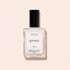 A clear square bottle of Manucurist Nebula nail polish with a black cap and white label, filled with shimmery holographic polish, is photographed on a pale beige background.