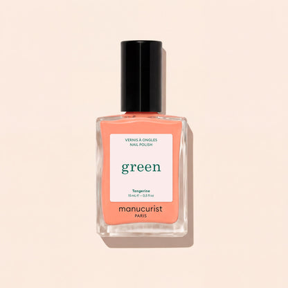 Manucurist Tangerine nail polish features a light orange shade with a black cap and white label with green and black text, shown against a light beige background. This vibrant color adds a lively pop to your look.
