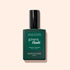 A dark green bottle of Manucurist Vitaminized Base Coat Green Flash™ with KeraHCE+ stands upright on a light beige background. The label displays white text and the Green Flash logo.