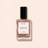 A bottle of Manucurist nail polish in the shade Sandstone, a shimmery rose gold hue, displayed against a light beige background.