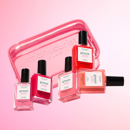Five bottles of Manucurist nail polish in pink and coral shades are arranged before a translucent Manucurist Mini Jelly Bag, ideal for storing your polish, all set against a soft pink gradient background.