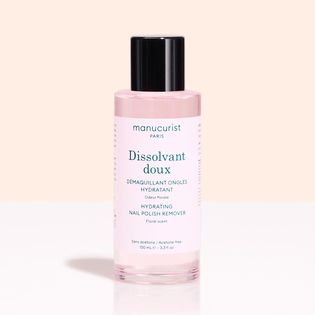 A pink bottle of Manucurist Gentle Remover with a black cap sits against a light pink background. The label notes it&