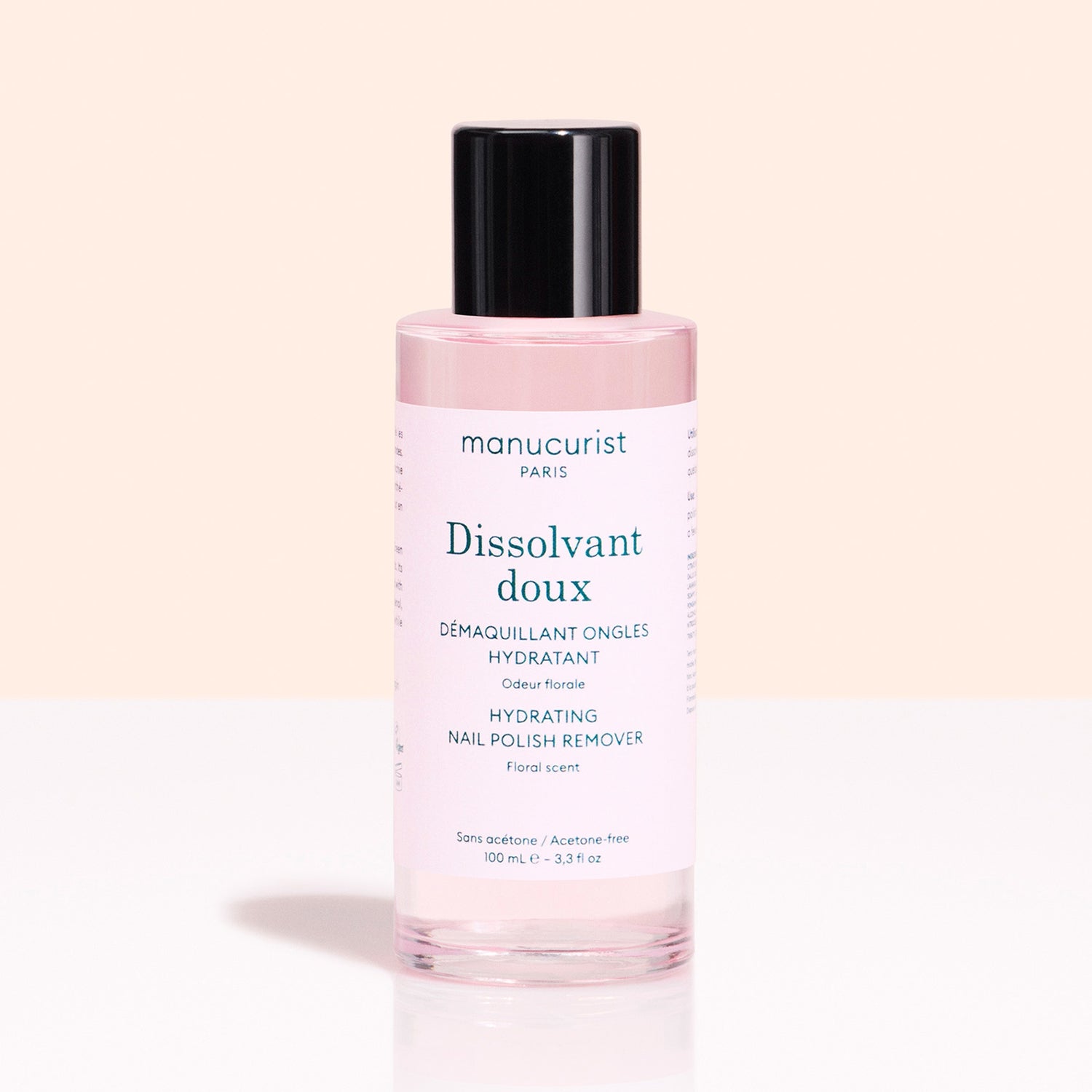 A pink bottle of Manucurist Gentle Remover with a black cap sits against a light pink background. The label notes it&