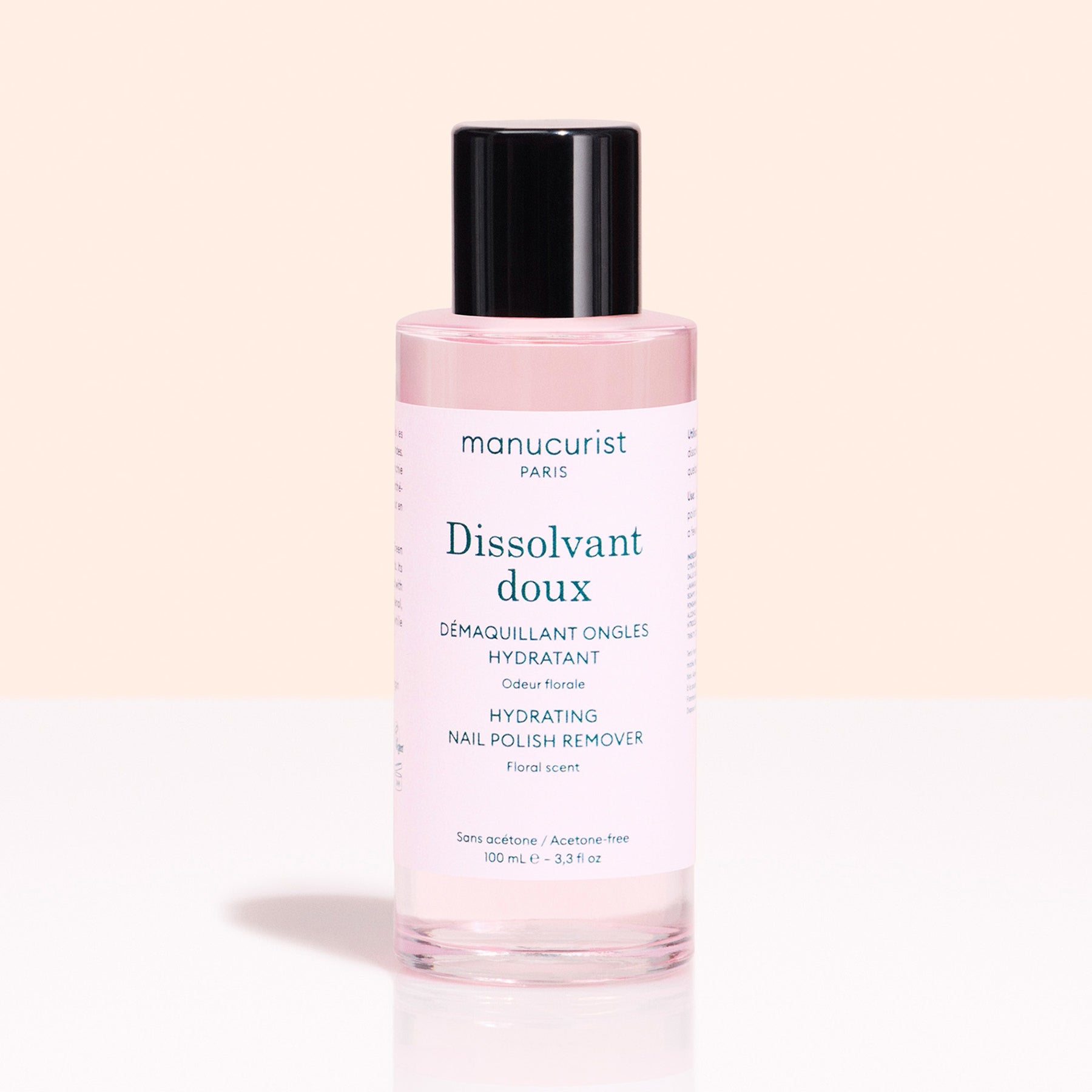 A pink bottle of Manucurist Gentle Remover with a black cap sits against a light pink background. The label notes it&