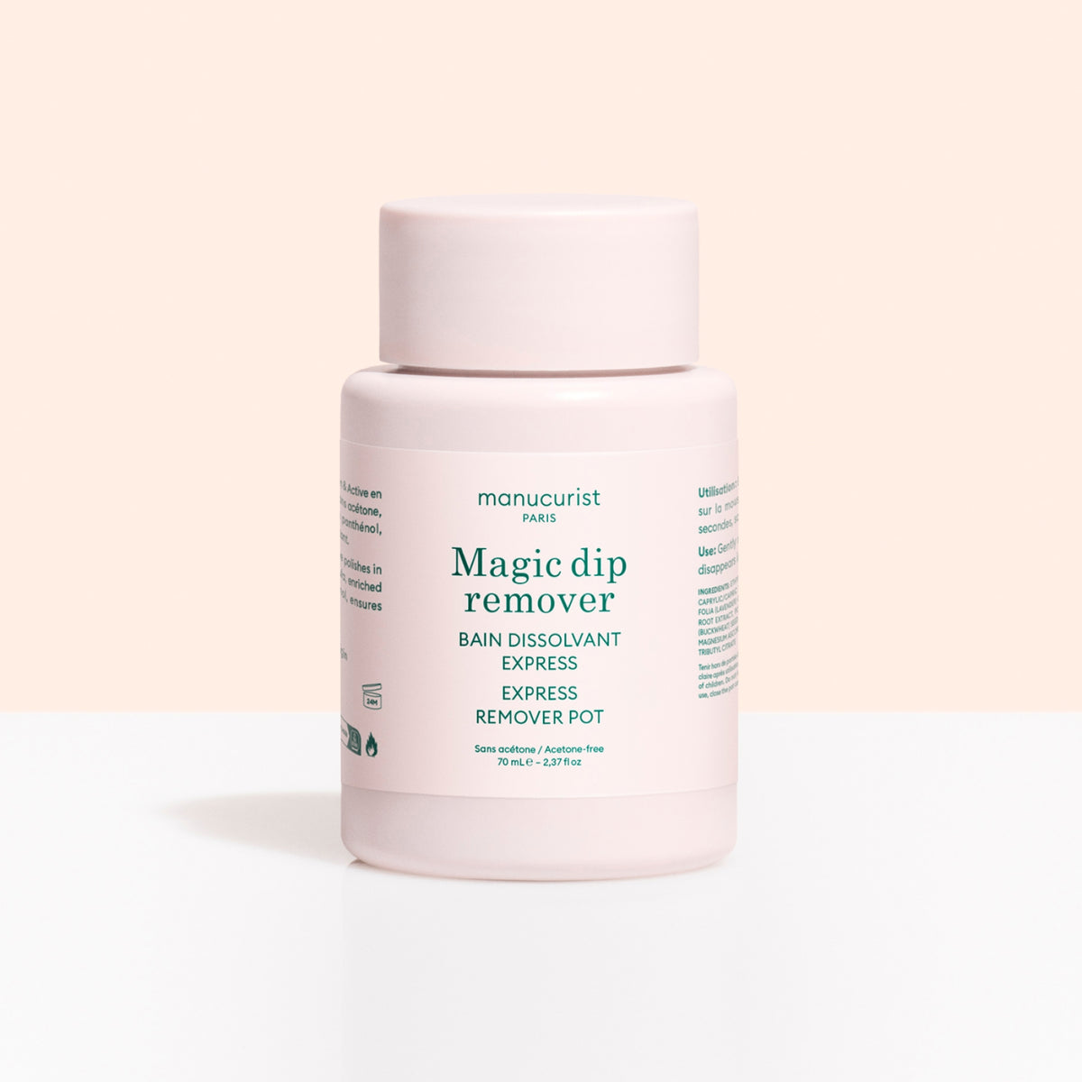 A light pink plastic container labeled Magic Dip Remover by Manucurist, this acetone-free express nail polish remover is perfect for travel touch-ups, shown against a pale beige and white background.