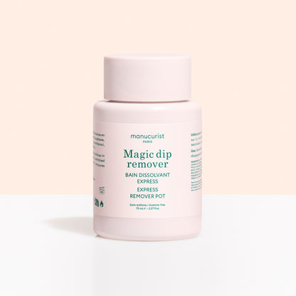 A light pink plastic container labeled Magic Dip Remover by Manucurist, this acetone-free express nail polish remover is perfect for travel touch-ups, shown against a pale beige and white background.