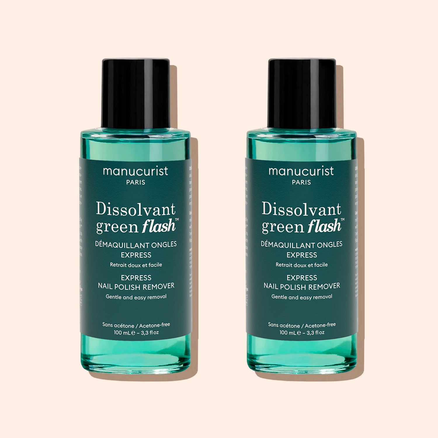 Two identical bottles of Manucurist Green Flash™ Gel Polish Remover with teal liquid, black caps, and white labels stand side by side on a beige background.