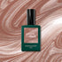 A bottle of Manucurist Sandstone rests on a swirling, shimmering marbled background in shades of latte brown and beige.