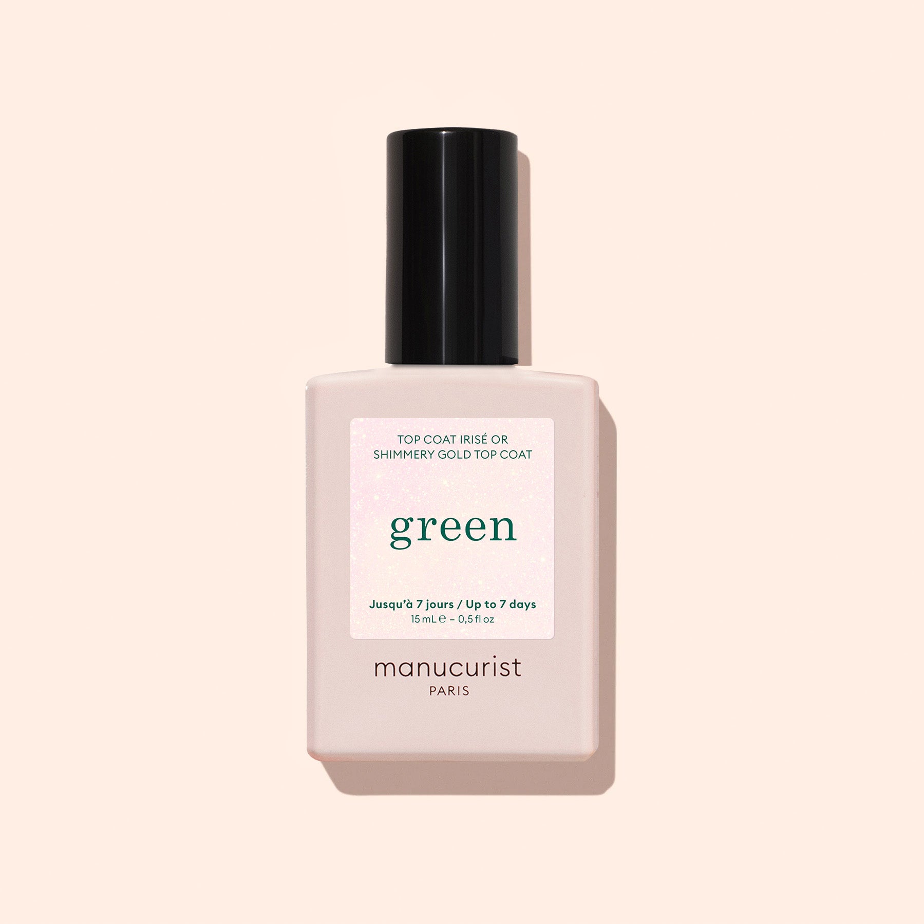 A bottle of Manucurist Glitter Top Coat, in a pale pink square bottle with a black cap and white label on a light beige background, offers an express air-drying formula for a smooth, gel-like finish.