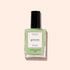 Un flacon de vernis à ongles botanique Milky Matcha de Manucurist vert, avec un bouchon noir et une étiquette minimaliste, sur fond beige clair.
